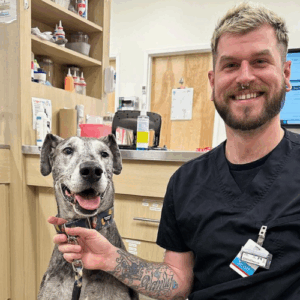 UrgentVet employee with large smiling dog
